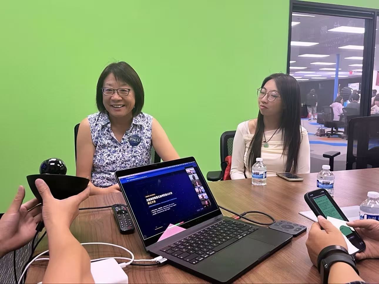 图：李萍（左）在现场与参会者交流